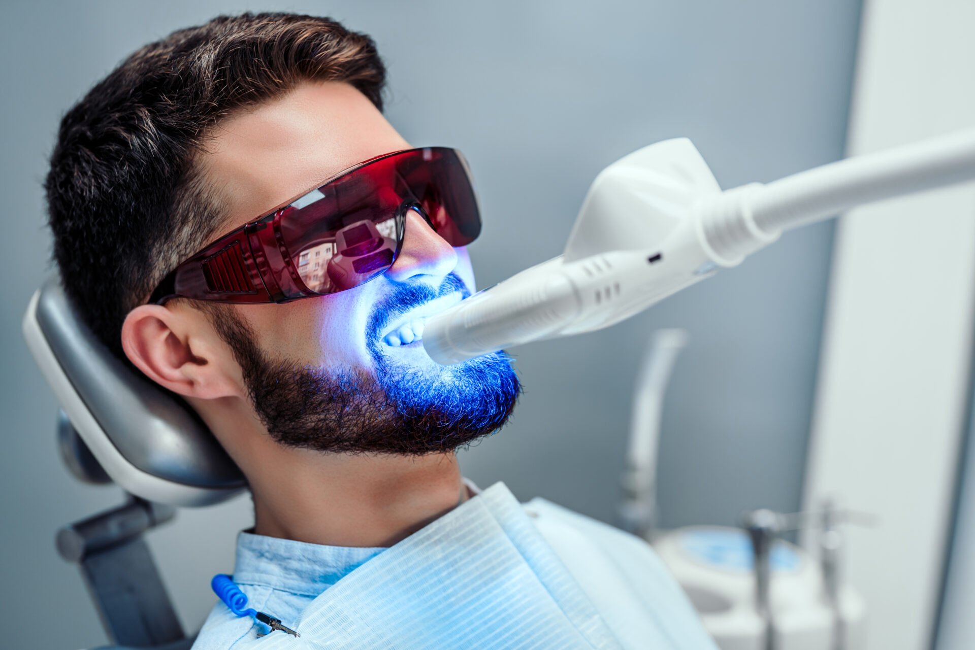 Close,Up,View,Of,Man,Undergoing,Laser,Tooth,Whitening,Treatment